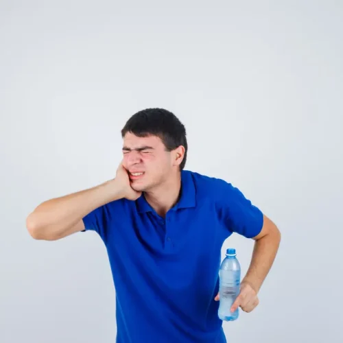 Young man holding his cheek because of pain after an extraction